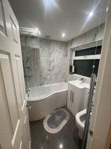 a bathroom with a tub sink and a toilet at Impeccable 3-Bed House in York in York