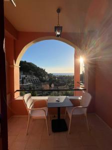 balcón con mesa, sillas y ventana en Aphrodite Apartments, en Agios Gordios