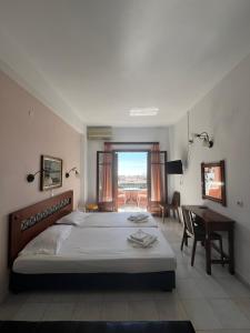 1 dormitorio con cama, mesa y escritorio en Aphrodite Apartments, en Agios Gordios