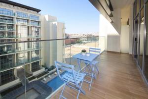 a balcony with a table and chairs in a building at Silk Valley - Furnished 1bhk With Pool And Gym in Abu Dhabi