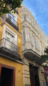 un edificio giallo con balconi sul lato di Hotel Life Gran Via Design a Madrid