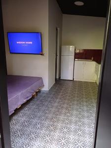 Romeo suite في حيفا: غرفة بها تلفزيون على الحائط ومطبخ
