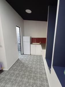 uma cozinha vazia com armários brancos e piso em azulejo em Romeo suite em Haifa