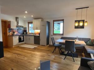 a kitchen and living room with a table and chairs at Alpentime Apartments in Neustift im Stubaital