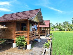 two people are standing in a house in a field at Padi Bungalows in Tetebatu