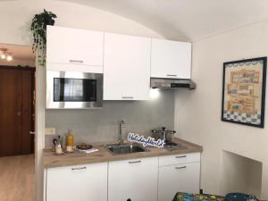 a kitchen with white cabinets and a sink at House Vincent by Holiday World in Turin