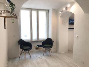 two chairs in a room with a table and two windows at House Vincent by Holiday World in Turin