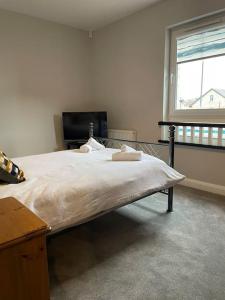 Schlafzimmer mit einem großen Bett und einem Fenster in der Unterkunft Belfast Luxury: Spacious 2BR Home Near Stormont in Belfast