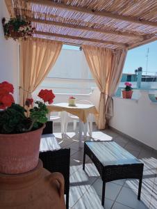 a patio with a table and chairs and a window at L'alloggio delle vacanze estive in Corsano