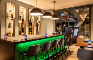 a green bar with chairs and tables in a restaurant at Leonardo Boutique Hotel Berlin City South in Berlin