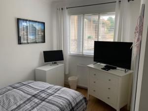 1 dormitorio con 1 cama y TV de pantalla plana en Crayford's Guest House, en Aberdeen