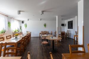 een eetkamer met houten tafels en stoelen bij Penzion JAAL in Příbor