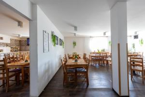 une salle à manger avec des tables et des chaises en bois dans l'établissement Penzion JAAL, à Příbor