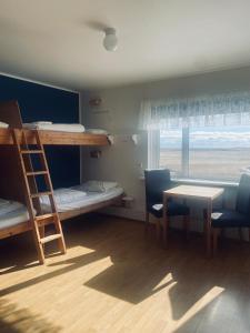 a room with bunk beds and a table and chairs at Vagnsstadir in Borgarhöfn