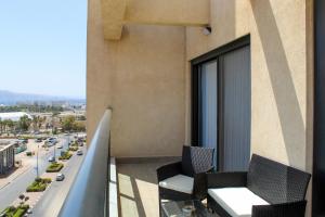 uma varanda com 2 cadeiras e vista para a cidade em Suite Apartment #22 By Hashdera Eilat em Eilat