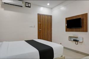 a bedroom with a bed and a tv on the wall at Hotel Stay Prime in Pune