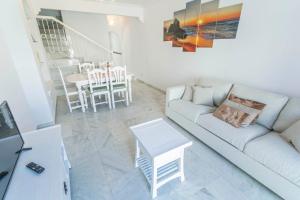 un soggiorno con un divano e un tavolo di Canovas Nerja - Casa adosada con piscina Los Huertos 3 a Nerja