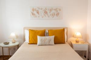 a bedroom with a bed with two tables and two lamps at Casa Ardomar in Carrapateira