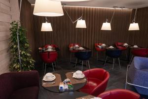 un ristorante con sedie rosse, tavoli e luci di Stendhal Luxury Suites a Roma