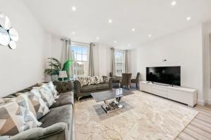 a living room with a couch and a tv at The Grosvenor Residences in London