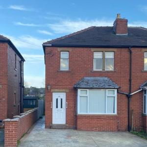 a red brick house with a white door at Cosy Semi-detached House To Stay In West Yorkshire in Heckmondwike