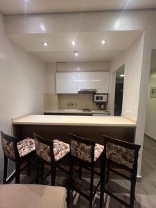 a kitchen with a bar with four chairs and a counter at Ny Suites in Beirut
