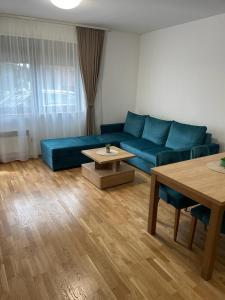 sala de estar con sofá azul y mesa en Apartment Nikolic, en Zlatibor