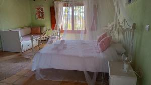 ein Schlafzimmer mit einem weißen Bett mit rosa Kissen in der Unterkunft Sunny Vista in Pinoso