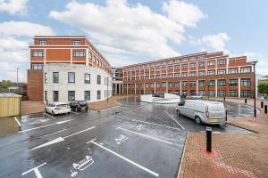 un estacionamiento frente a un gran edificio en Roomspace Serviced Apartments- Syward Place, en Chertsey