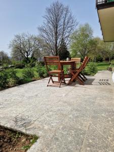 two wooden chairs and a table on a patio at L'Oasi Amena in Ameno