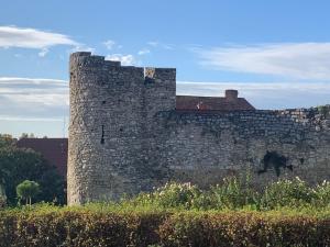 an old stone wall with a building behind it at Wellness Hotel Várfal in Pécs