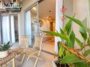 un porche con 2 sillas y una planta en The Sóng Hotel & Apartment Vũng Tàu - VTLand, en Vung Tau
