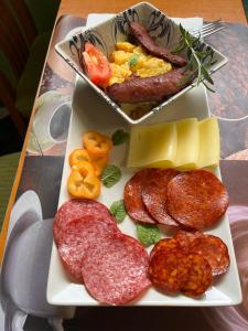 uma bandeja com diferentes tipos de carnes e queijos em Wellness Hotel Várfal em Pécs