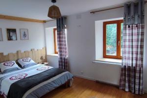 Schlafzimmer mit einem Bett und einem Fenster in der Unterkunft Chez mémé in Engenthal