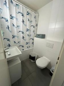 a bathroom with a toilet and a shower curtain at High standing apartment in Ouchy - Lausanne in Lausanne