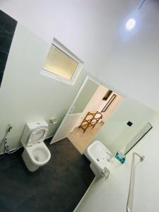 łazienka z 2 toaletami, umywalką i lustrem w obiekcie LaRoy Mirissa- Introducing Smart Room w mieście Mirissa