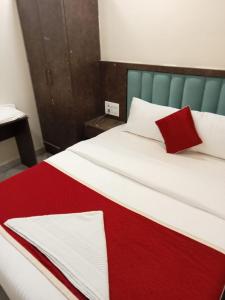 孟買的住宿－THE B TOWN HOTEL (MHADA)，床上有红白毯子