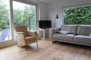 a living room with a couch and two chairs and a television at Zeealsem in Ballum