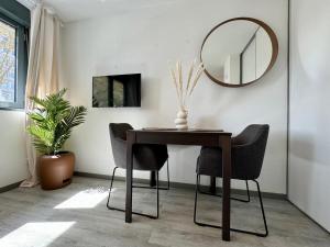 a dining room table with chairs and a mirror at Suite Bahia in Lyon