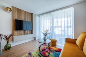 a living room with a couch and a tv at MyFlat Wave Olive Apartment in Siófok