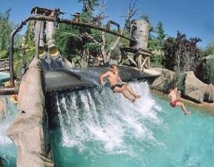 two men riding a water slide at a water park at Residence Belvedere ristrutturato vista Wifi in Caprino Veronese