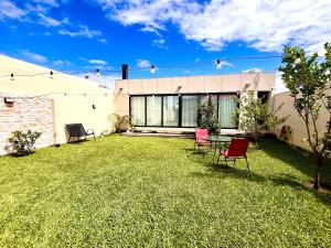 a backyard with chairs and a table on the grass at Verde Limon Loft (monoambiente) in San Salvador de Jujuy