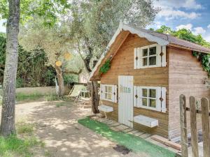 a small wooden cabin with a fence in a yard at Xauxa in Sant Pere de Vilamajor