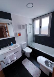 a bathroom with a white toilet and a sink and a tub at Renthas Torre Lugano in Benidorm