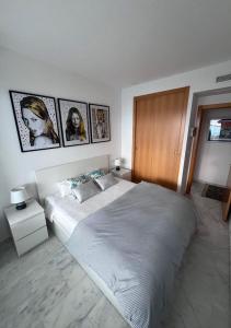 a bedroom with a large bed with pictures on the wall at Renthas Torre Lugano in Benidorm