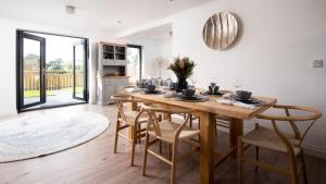 Sunwick Cottage في Hutton: غرفة طعام مع طاولة وكراسي خشبية