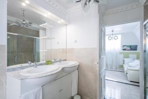 a white bathroom with a sink and a mirror at Appartement Emeraude - Paris à 13 minutes in Deuil-la-Barre