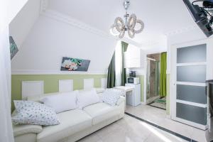 a living room with a white couch and a chandelier at Appartement Emeraude - Paris à 13 minutes in Deuil-la-Barre