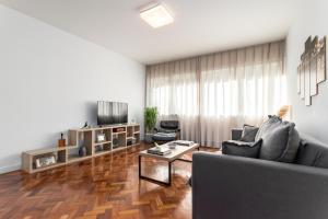 uma sala de estar com um sofá e uma mesa em Unhotel - Charmoso Apartamento Temporada com 3 quartos em Copacabana no Rio de Janeiro
