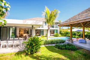 an exterior view of a house with a patio and a yard at Marguery Villas in Rivière Noire